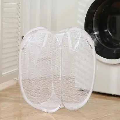 White mesh foldable laundry basket by Clarify.pk placed on wooden floor near washing machine