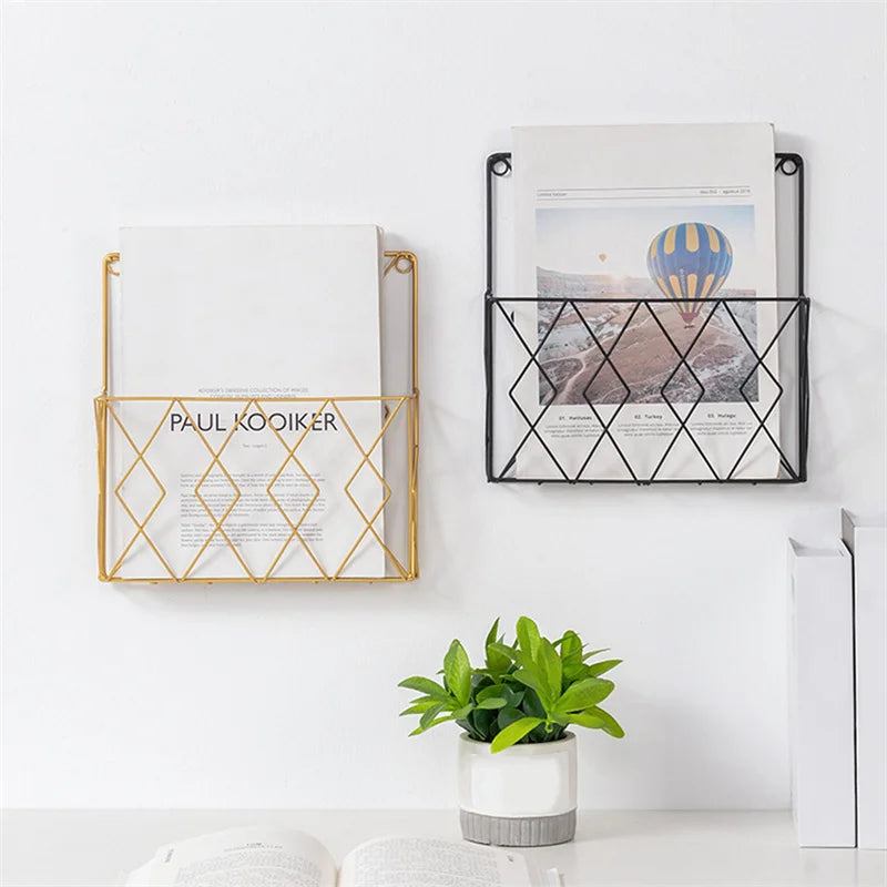 Two metal wall mounted rack holders in gold and black for organizing magazines and documents on white wall