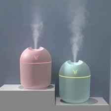 Clarify mini air humidifier 250ml in pink and green emitting mist on display