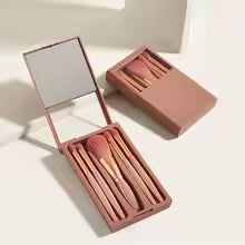 Mini makeup brush set with case featuring multiple brushes in rose gold tones inside a compact storage box
