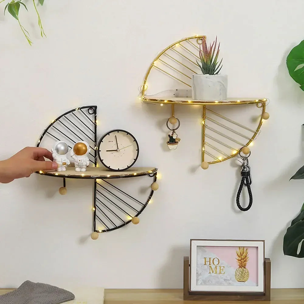 Minimalist home decor shelf set with black and gold wire design holding small plants and decorative items