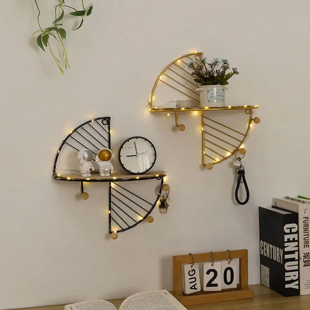 Black and gold minimalist home decor shelf with hooks holding decorative items and plants