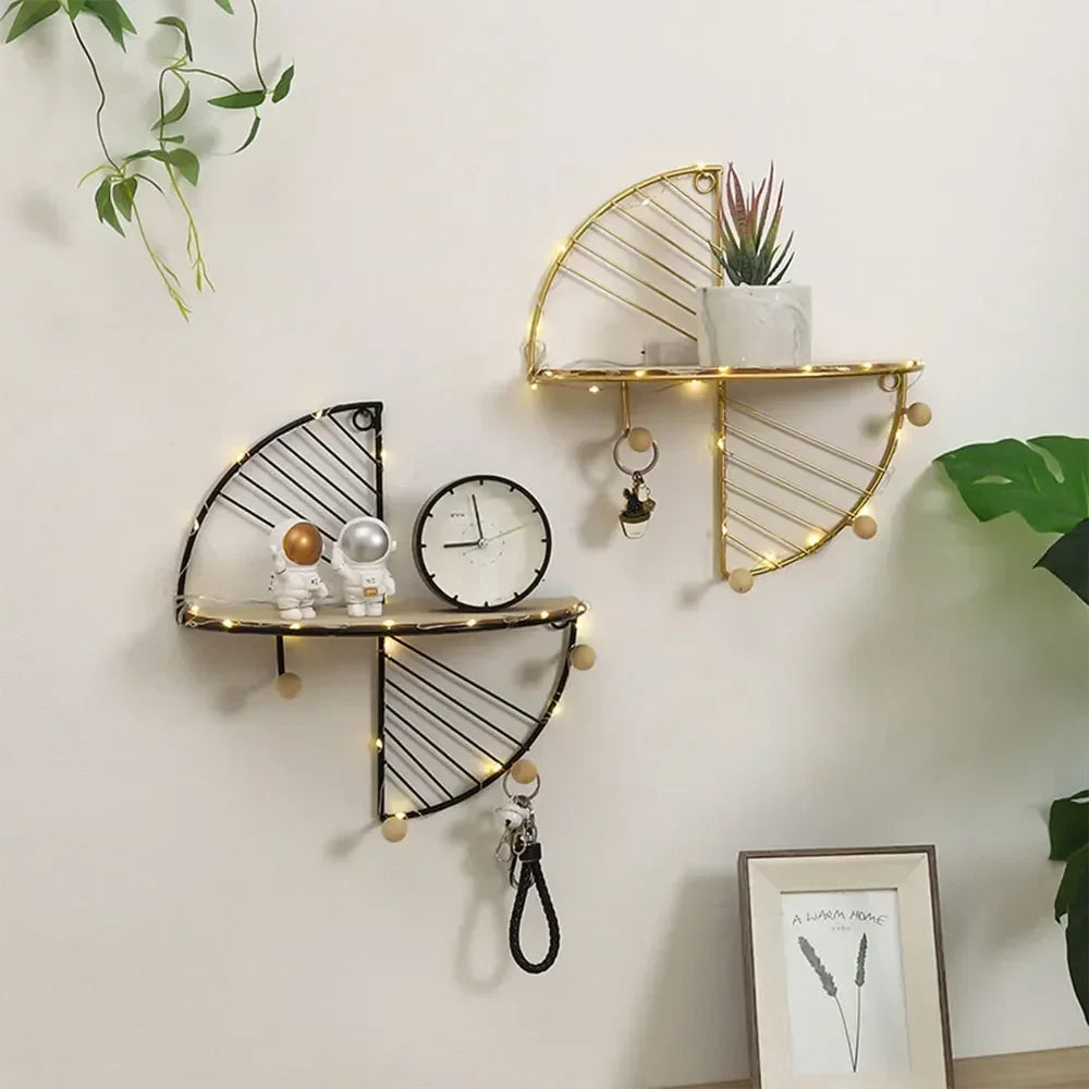 Minimalist home decor shelf set with black and gold geometric metal frames holding small decor items and lights