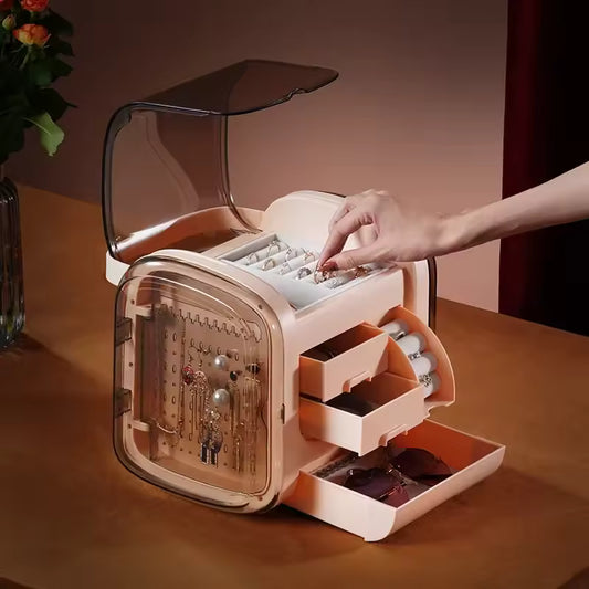 Modern jewelry storage box with drawers in beige color showing various compartments and clear top cover