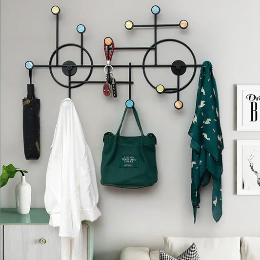 Modern wall mounted coat stand with colorful hooks holding umbrella, white shirt, green bag, and scarf