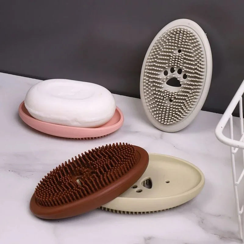 Multifunctional silicone soap box with built-in scrubber bristles in various colors holding a white soap bar