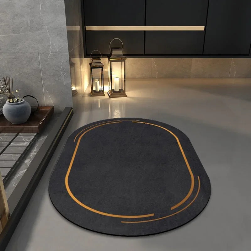 Gray oval-shaped non slip bathroom mat with orange accents on a sleek modern bathroom floor