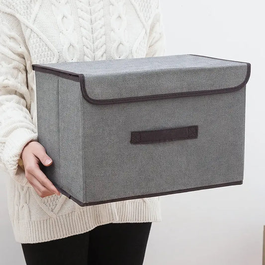 Clarify.pk gray non woven storage box with lid held by person wearing white sweater