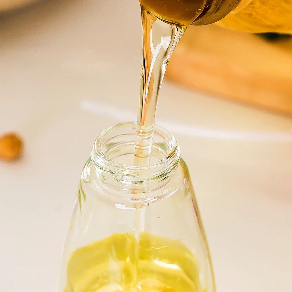Pouring oil into a clear glass bottle oil sprayer for kitchen use by Clarify.pk