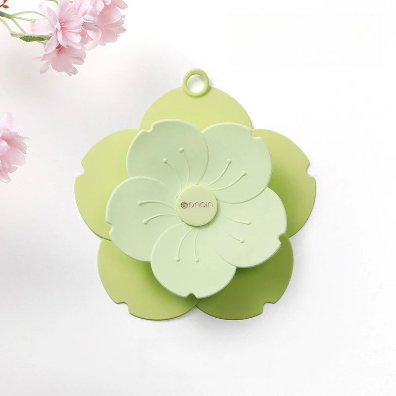 Clarify.pk green silicone drain cover for bathroom shaped like a flower with a hanging loop
