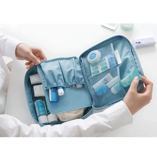Blue makeup storage bag for women with multiple compartments holding skincare and cosmetic products
