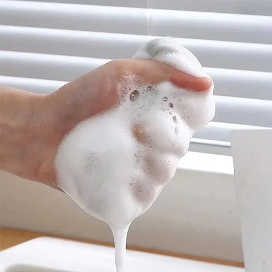 Hand holding foam created by pack of 3 double sided kitchen sponge from Clarify.pk for effective cleaning