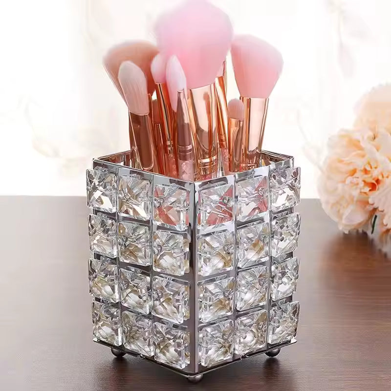 Crystal makeup brush holder with clear decorative crystals holding pink and rose gold brushes