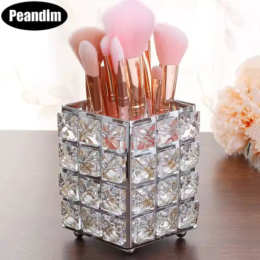 Crystal makeup brush holder with square crystal design holding pink makeup brushes on wooden surface