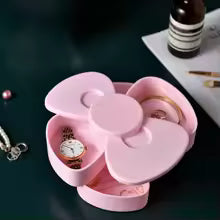 Pink 360 degree bow rotating jewelry box by Clarify.pk holding rings and a watch
