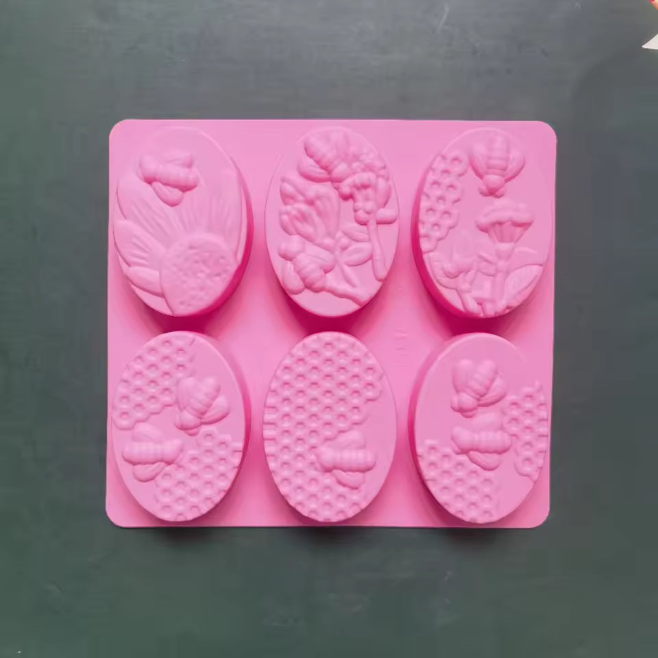 Pink 6 cavity oval soap mold with floral and bee designs by Clarify.pk for handmade soap crafting