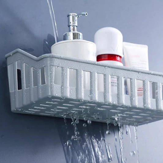 Gray plastic bathroom shelf organizer mounted on wall holding toiletries with water dripping