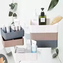 Plastic desktop organizer box in striped neutral colors holding skincare and beauty products