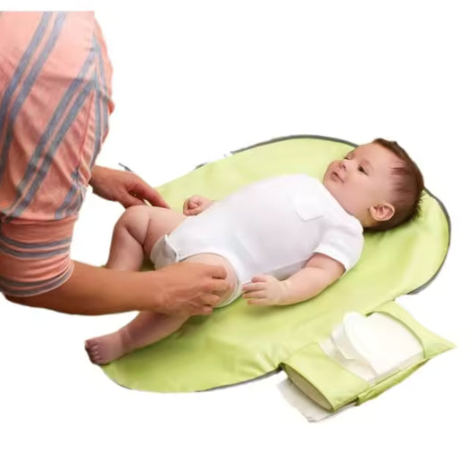 Clarify.pk waterproof baby changing mat in green with a baby lying on it and an adult changing the diaper