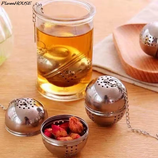 Clarify.pk stainless steel tea leaves diffuser ball with chain steeping tea in glass cup