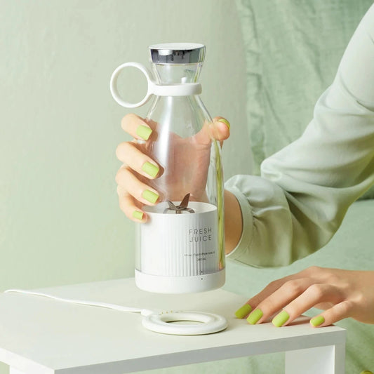 Clarify.pk portable electric juicer blender with transparent bottle and white base held by hand
