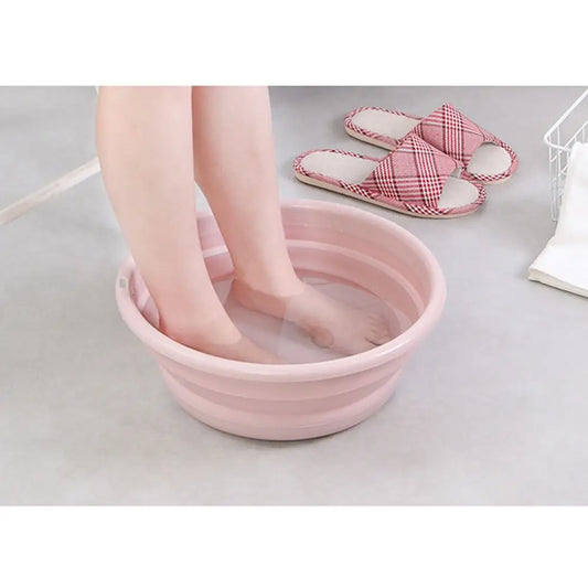 Clarify.pk portable folding laundry tub in pink with feet soaking inside on gray floor