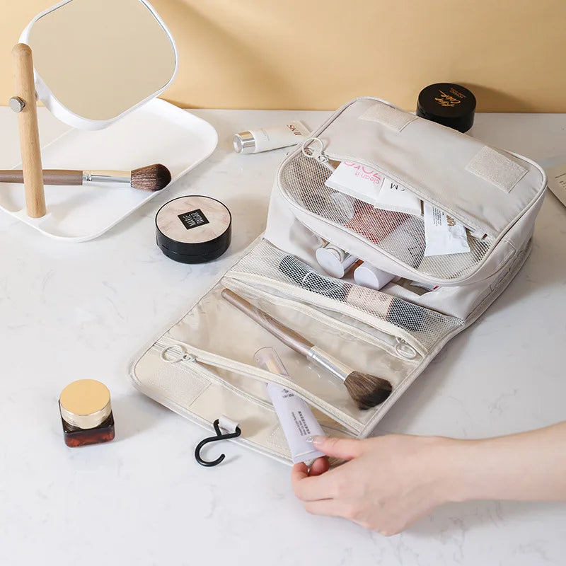 Clarify.pk portable hanging toiletry bag open with makeup brushes and cosmetics inside on white marble surface