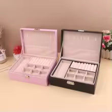 Portable jewelry box for girls in pink and black with multiple compartments for organizing accessories