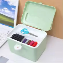 Portable medicine chest with handle in light green color holding scissors and markers on a desk