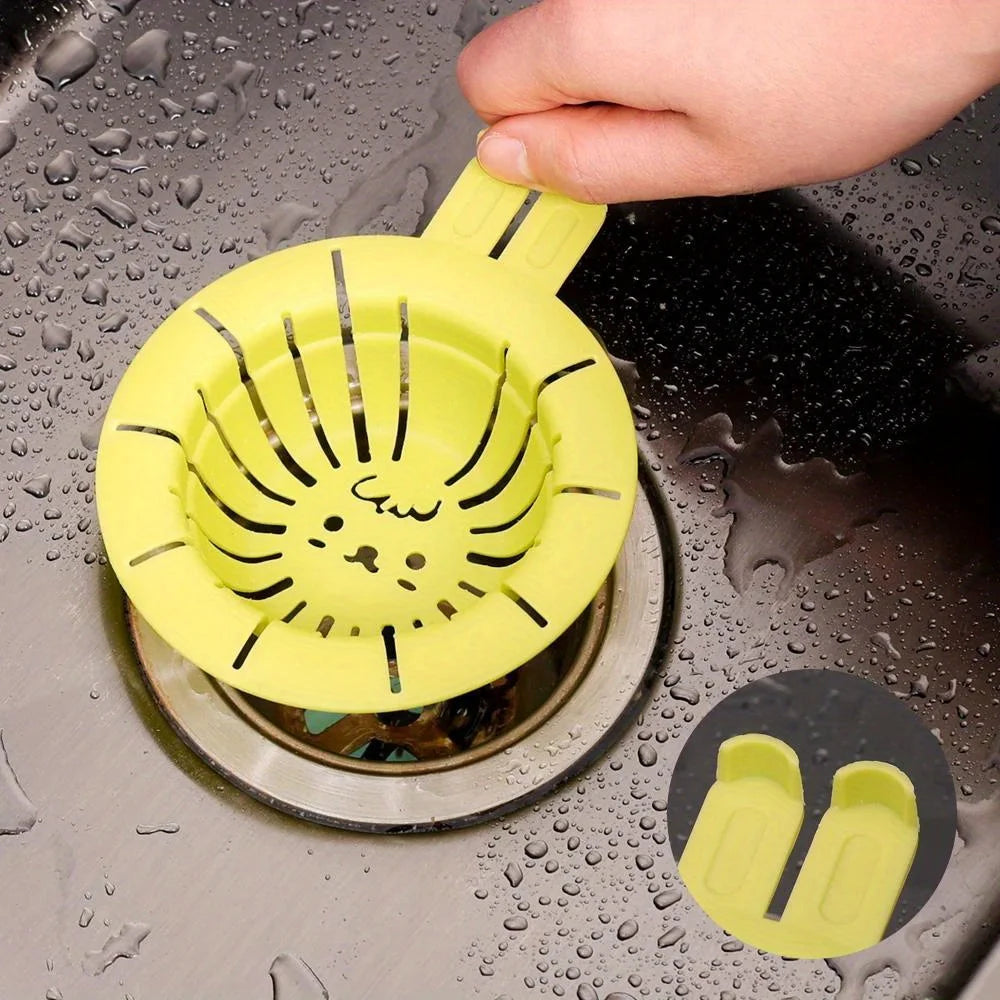 Yellow rabbit drain basket strainer with a cute rabbit face design held over a kitchen sink drain