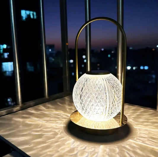 Clarify.pk retro metal table lamp with a glowing textured glass orb and brass finish on a balcony at night