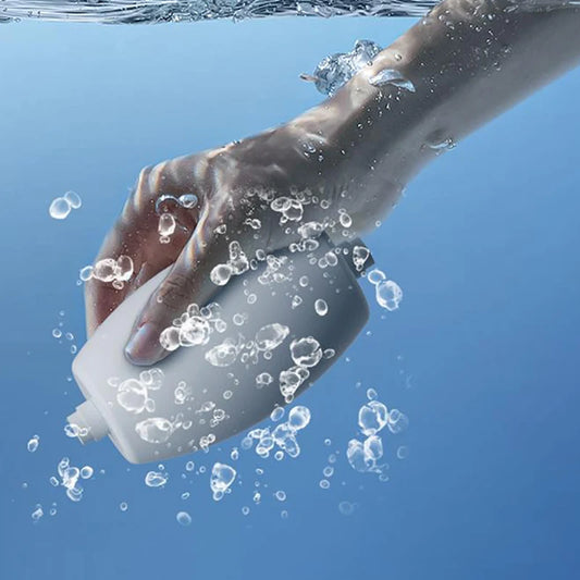 Hand holding reusable lint remover underwater with water bubbles surrounding it