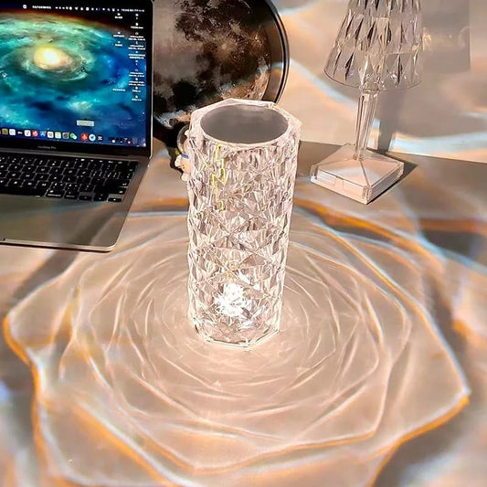 Clarify.pk rose crystal rechargeable lamp casting intricate light patterns on a desk near a laptop and moon decor