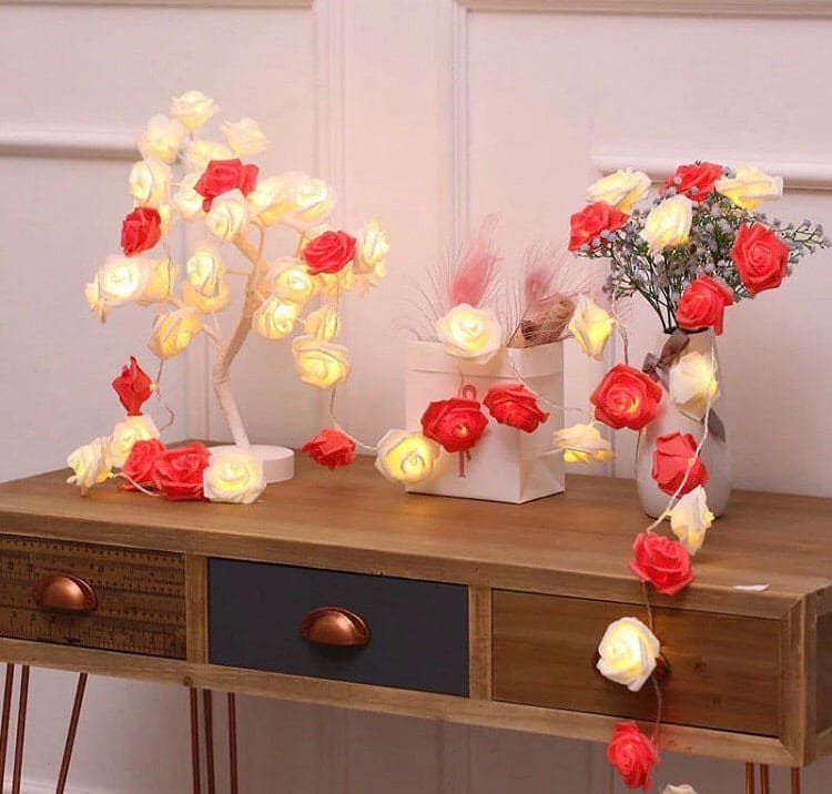 Rose fairy lights for bedroom decor featuring glowing red and white rose-shaped string lights on wooden table