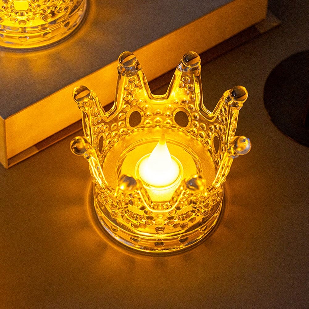 Illuminated crown night light decor with a glowing flame inside on a reflective surface