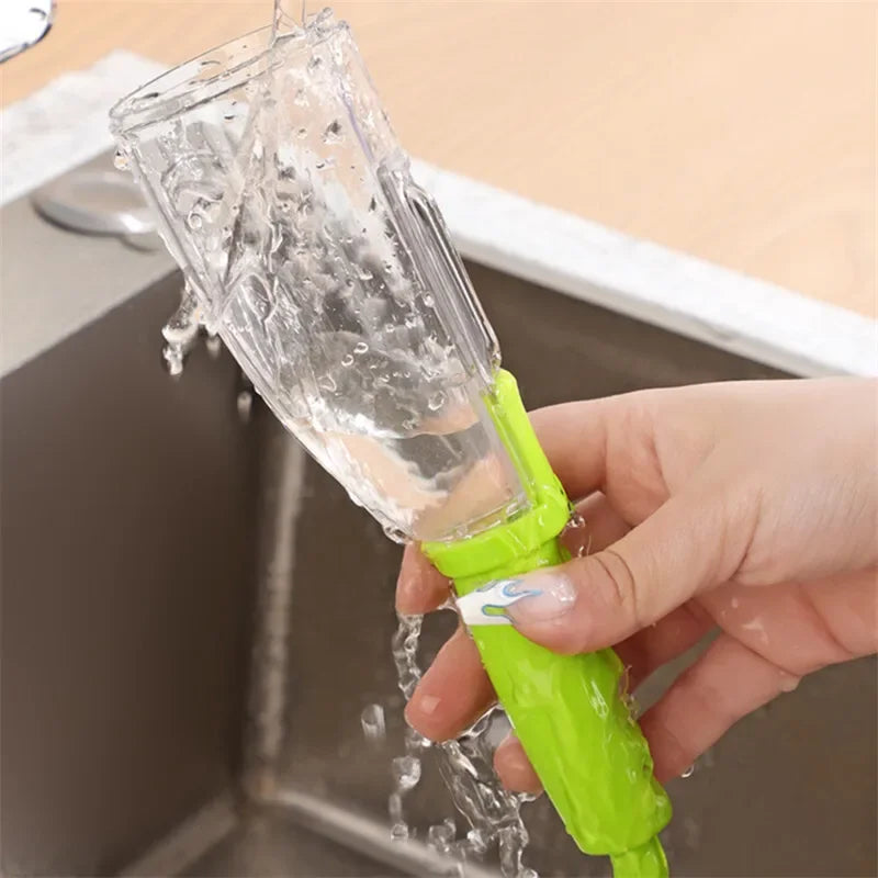 Green stainless steel fruit peeler being rinsed under running water in kitchen sink