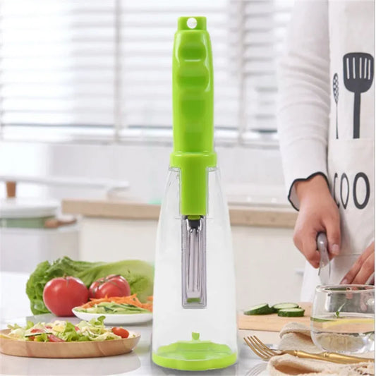 Stainless steel fruit peeler with green handle and clear storage box for home use on kitchen countertop