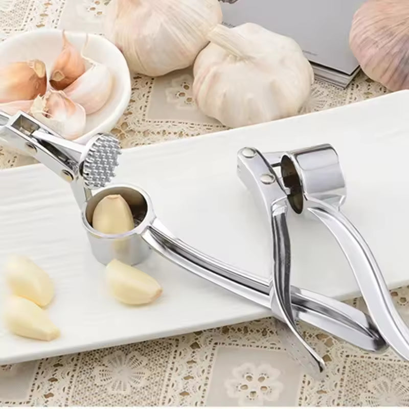 Clarify.pk stainless steel garlic press with ergonomic handle and fresh garlic cloves on white tray