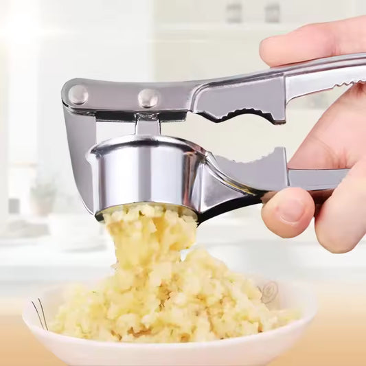 Hand using stainless steel garlic press to crush fresh garlic over a white bowl in kitchen