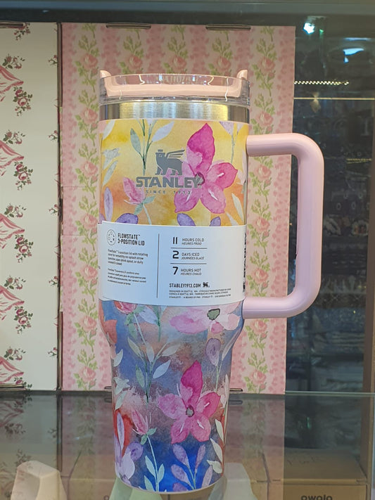 Stanley tumbler with pink handle and colorful floral design for hot and cold beverages