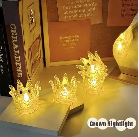 Set of three crown night light decor pieces glowing warmly on a desk with books and inspirational notes