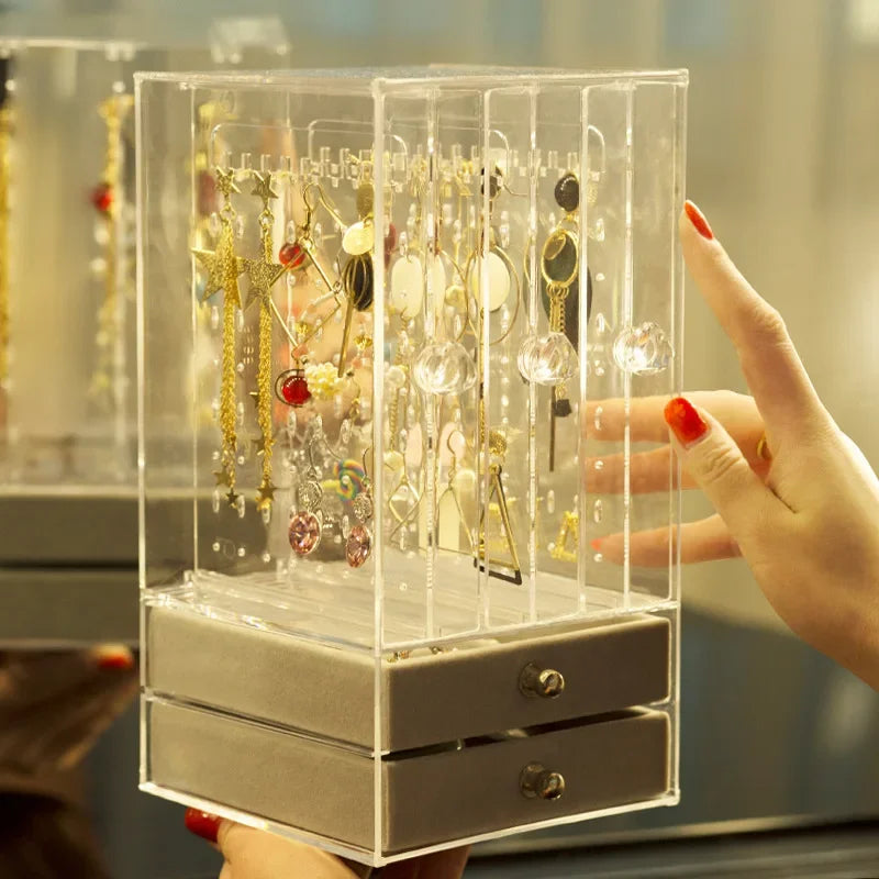 Transparent jewelry organizer box from Clarify.pk with multiple compartments holding various earrings