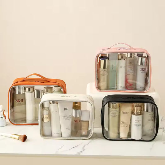 Set of transparent makeup bag cases in pink, orange, white, and black holding skincare products