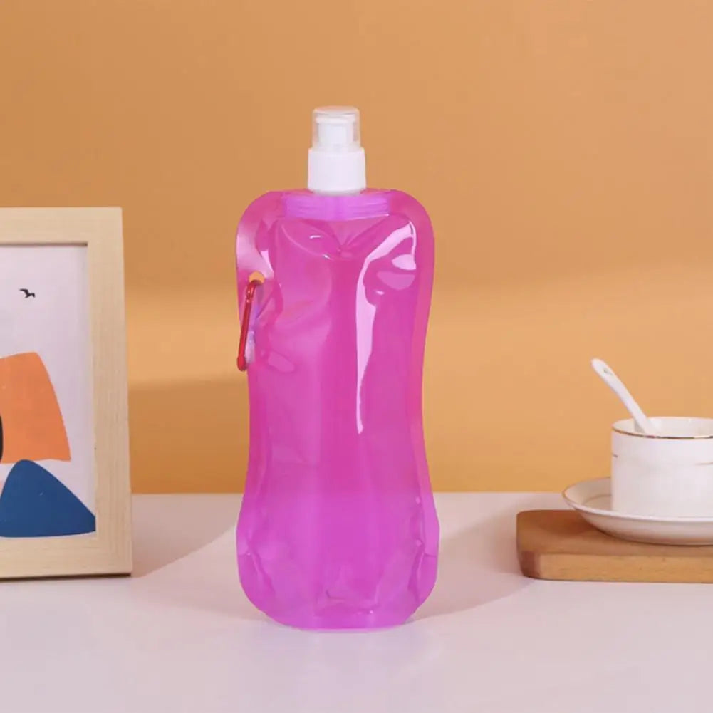 Pink ultralight foldable water container with white cap and orange clip on a table
