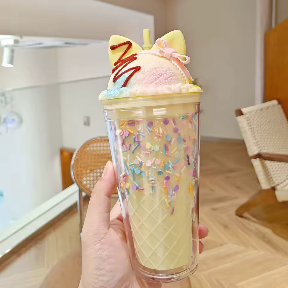 Unicorn water cup with straw featuring ice cream design and colorful sprinkles held in hand