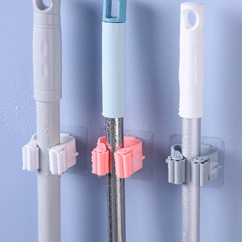 Clarify.pk broom mop wall clips in white pink and gray holding cleaning tools on blue wall