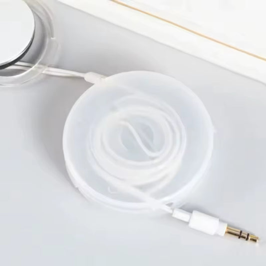 White data cable neatly coiled inside a round transparent data cable storage box on a white surface