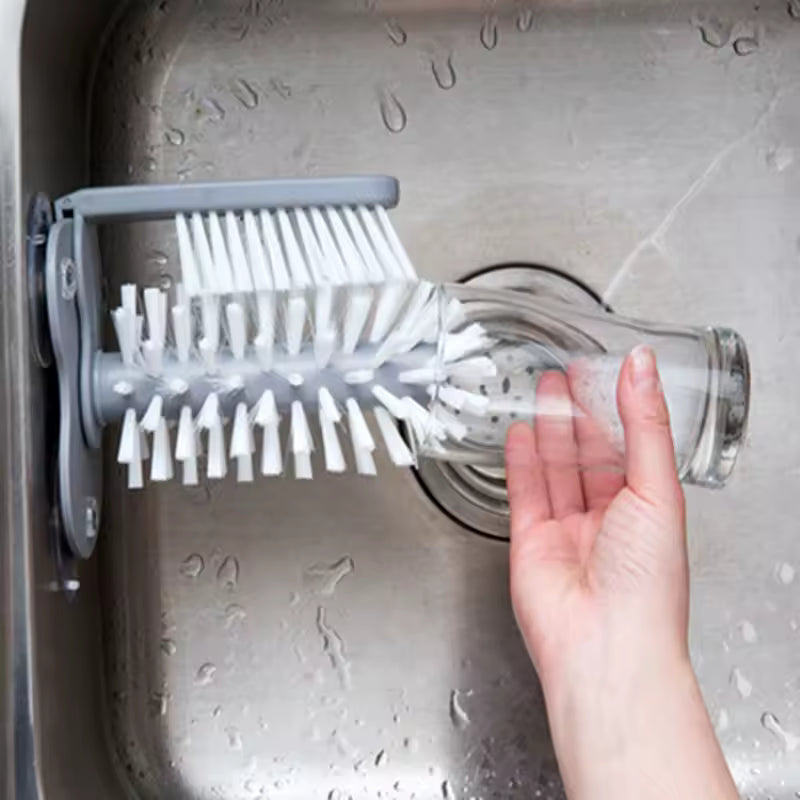 Clarify.pk sink bottle cleaning brush mounted in sink with hand holding glass for cleaning