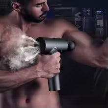 Man using a usb muscle relaxation device on his arm muscles in a gym setting