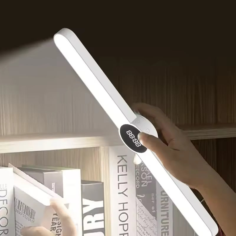 Hand adjusting Clarify.pk USB rechargeable LED desk lamp illuminating books on a shelf